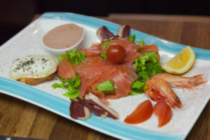 Zoom sur un plat du restaurant à base de saumon avec salade, crevettes, etc